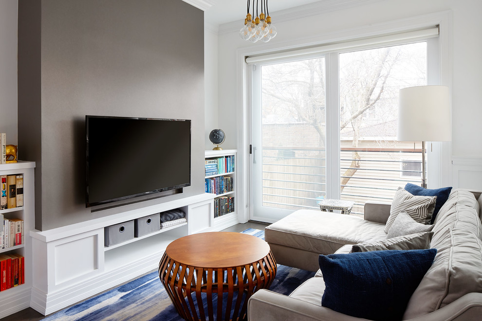 Diseño de sala de estar abierta tradicional renovada de tamaño medio sin chimenea con paredes grises, suelo de madera oscura, televisor colgado en la pared y suelo marrón