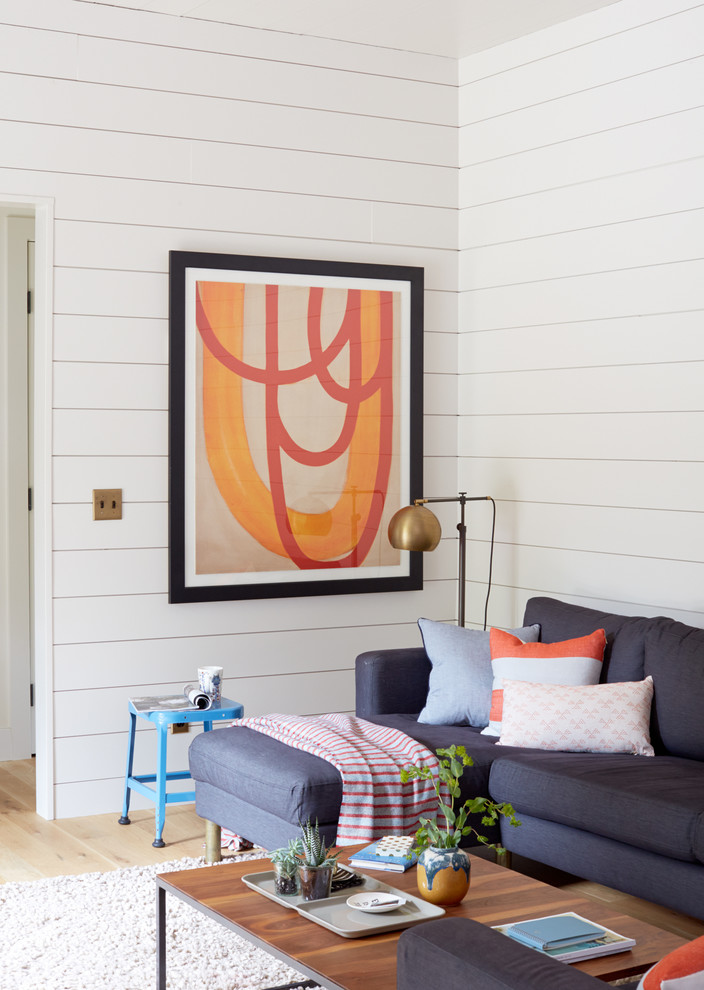 Ejemplo de sala de estar campestre con paredes blancas, suelo de madera clara y alfombra