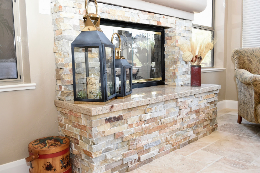 フェニックスにある中くらいなコンテンポラリースタイルのおしゃれなオープンリビング (ベージュの壁、トラバーチンの床、標準型暖炉、石材の暖炉まわり、壁掛け型テレビ、ベージュの床) の写真