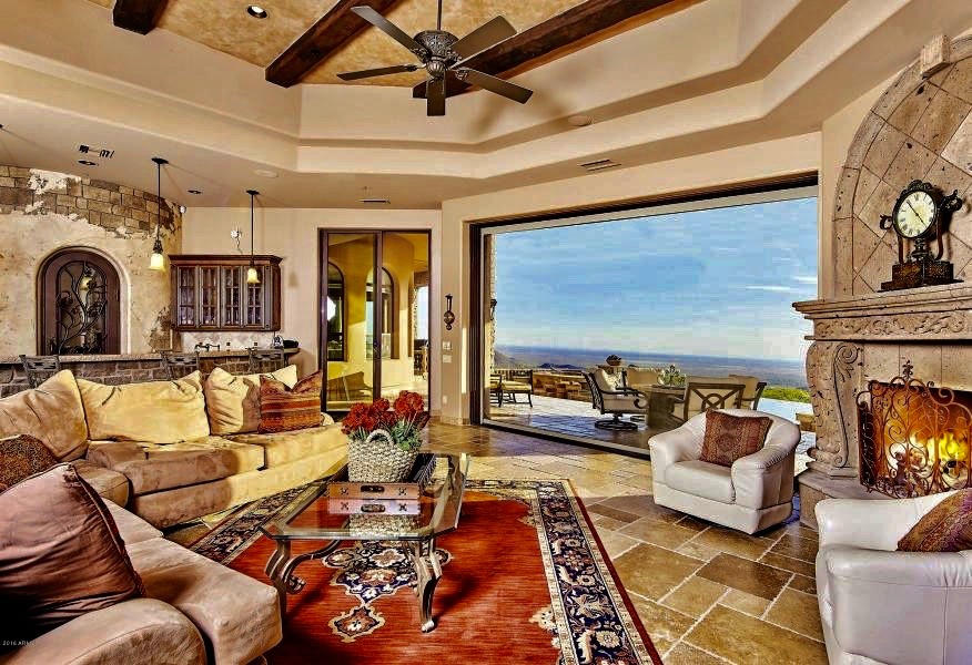 Large mountain style enclosed terra-cotta tile and beige floor family room photo in Phoenix with a bar, beige walls, a corner fireplace, a stone fireplace and no tv