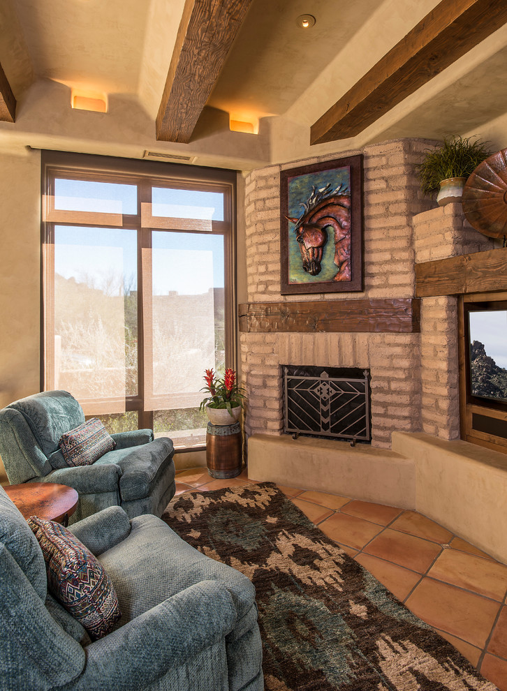 Ejemplo de sala de estar abierta de estilo americano de tamaño medio con paredes beige, suelo de baldosas de terracota, chimenea de esquina, marco de chimenea de ladrillo y pared multimedia