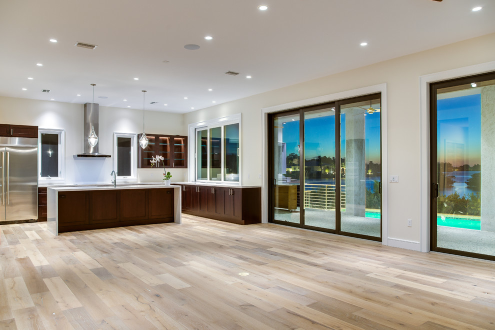 Medium sized contemporary open plan games room in Tampa with medium hardwood flooring, a wall mounted tv and beige walls.