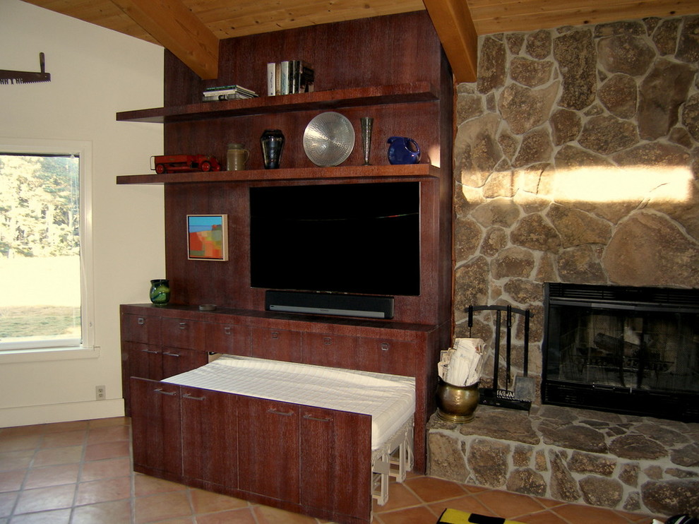 Modern inredning av ett mellanstort allrum med öppen planlösning, med klinkergolv i terrakotta, en standard öppen spis, en spiselkrans i sten och en väggmonterad TV