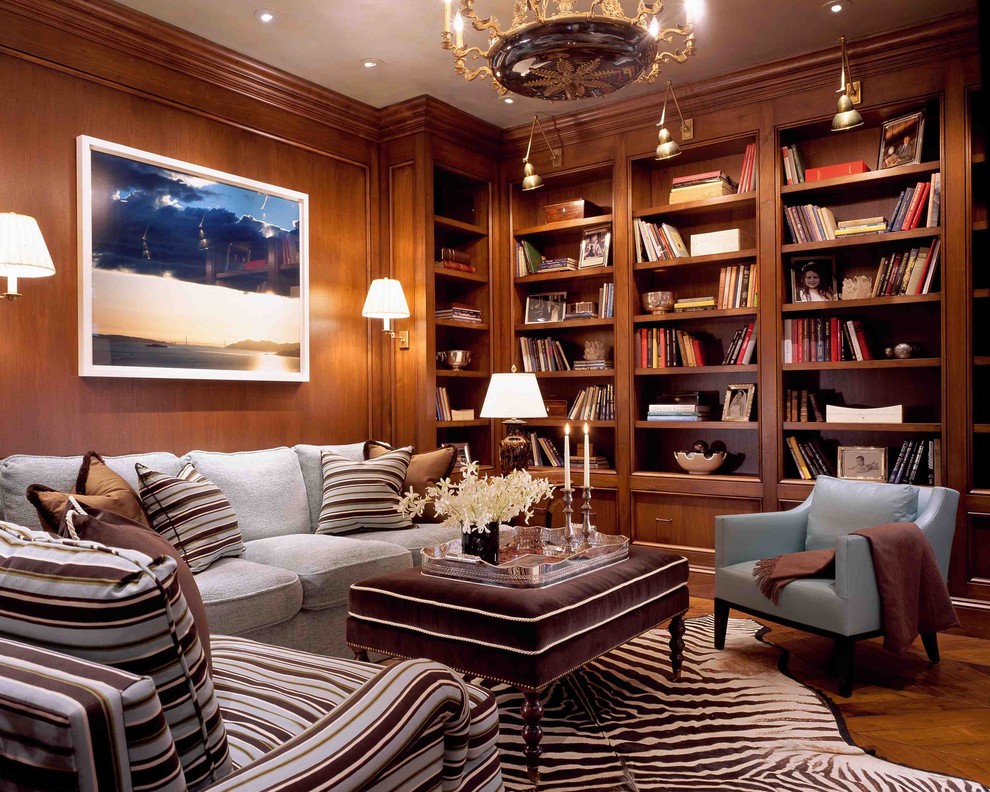 Imagen de sala de estar con biblioteca clásica con suelo de madera en tonos medios