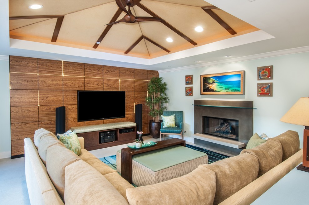 Foto di un soggiorno tropicale aperto con camino classico e TV a parete