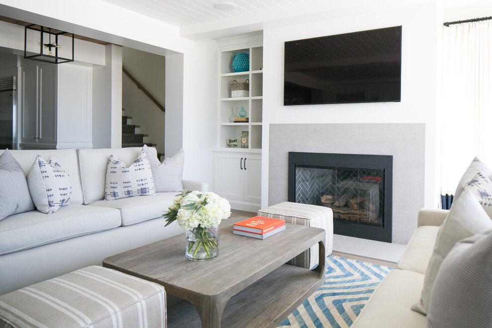 Offenes Maritimes Wohnzimmer mit weißer Wandfarbe, Kamin und Kaminumrandung aus Stein in Orange County