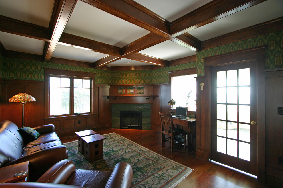 Cette image montre une salle de séjour craftsman de taille moyenne et fermée avec un mur vert, parquet foncé, une cheminée d'angle, un manteau de cheminée en brique et aucun téléviseur.