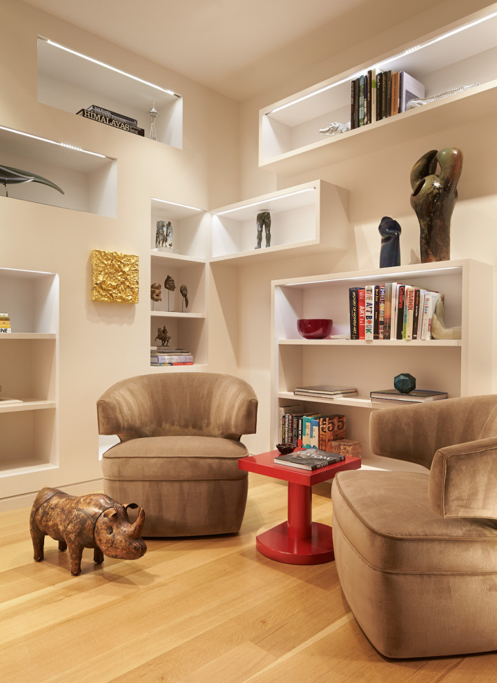 Modelo de sala de estar con biblioteca cerrada urbana pequeña con paredes beige, suelo de madera clara y suelo beige