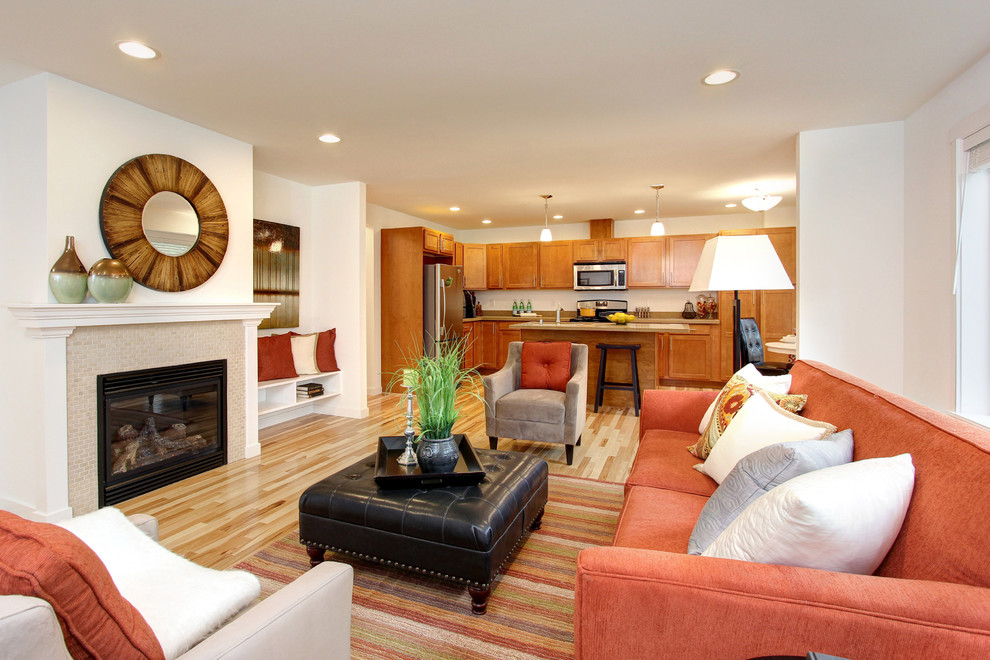 На фото: открытая гостиная комната среднего размера в стиле фьюжн с белыми стенами, светлым паркетным полом, стандартным камином, фасадом камина из плитки и телевизором на стене