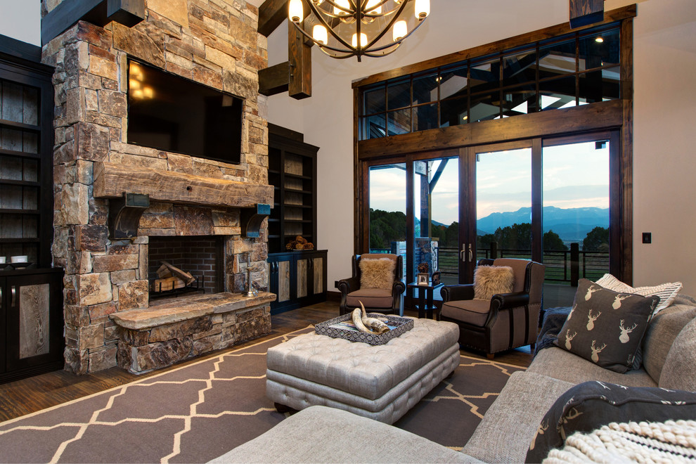 Photo of an expansive rustic open plan games room in Salt Lake City with white walls, carpet, a standard fireplace, a stone fireplace surround and a wall mounted tv.