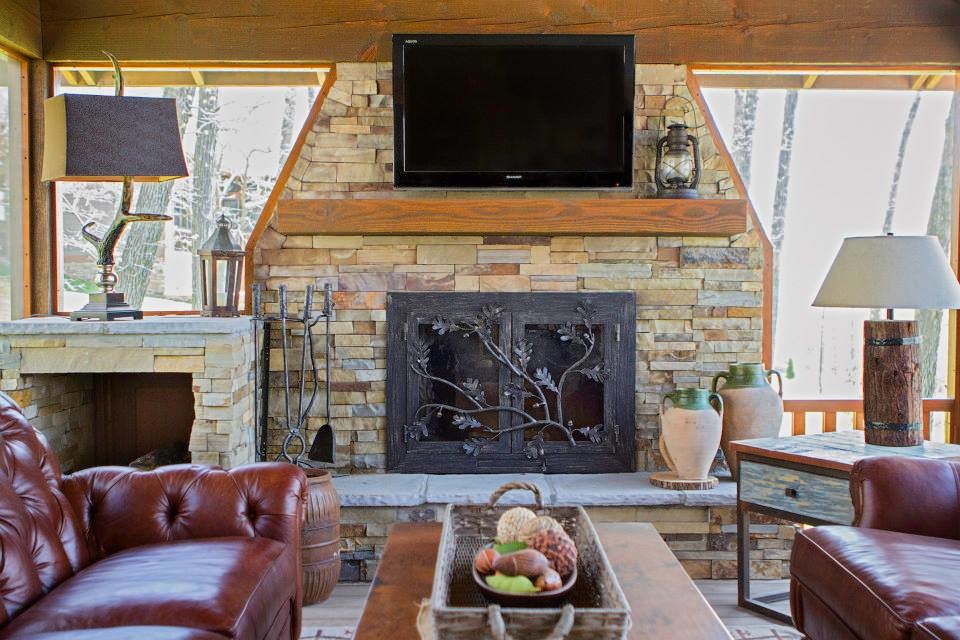 Inspiration for a large rustic enclosed games room in St Louis with grey walls, medium hardwood flooring, a standard fireplace, a stone fireplace surround and a wall mounted tv.