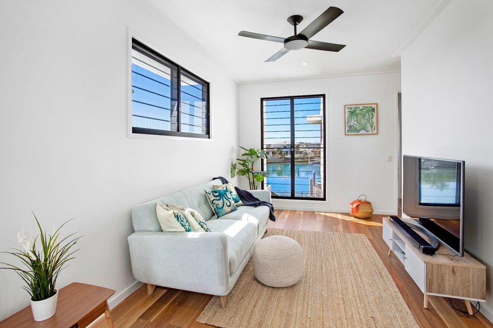 Kleines, Abgetrenntes Modernes Wohnzimmer mit weißer Wandfarbe, braunem Holzboden, freistehendem TV und braunem Boden in Gold Coast - Tweed