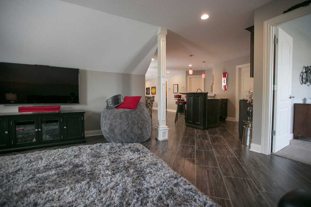 Example of a large trendy open concept vinyl floor and gray floor game room design in Kansas City with gray walls and a tv stand