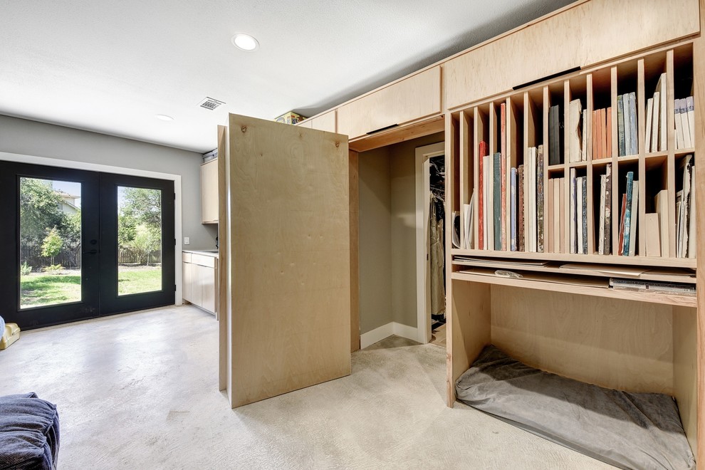Пример оригинального дизайна: большая изолированная гостиная комната в стиле модернизм с с книжными шкафами и полками, серыми стенами, бетонным полом и серым полом без телевизора