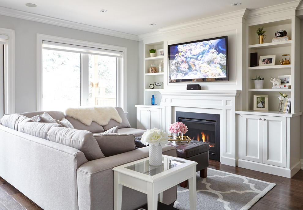 Mid-sized transitional open concept medium tone wood floor family room photo in Toronto with gray walls, a standard fireplace, a stone fireplace and a wall-mounted tv