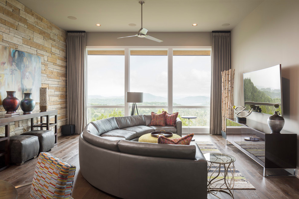 Immagine di un grande soggiorno design chiuso con pareti beige, parquet scuro, nessun camino, TV a parete e pavimento marrone