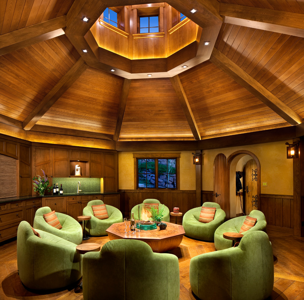 На фото: гостиная комната в стиле рустика с домашним баром, желтыми стенами и паркетным полом среднего тона с