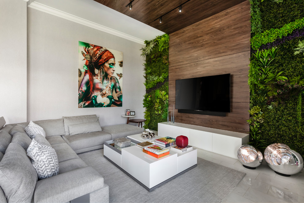 Свежая идея для дизайна: гостиная комната в современном стиле с белыми стенами, телевизором на стене, серым полом и ковром на полу - отличное фото интерьера