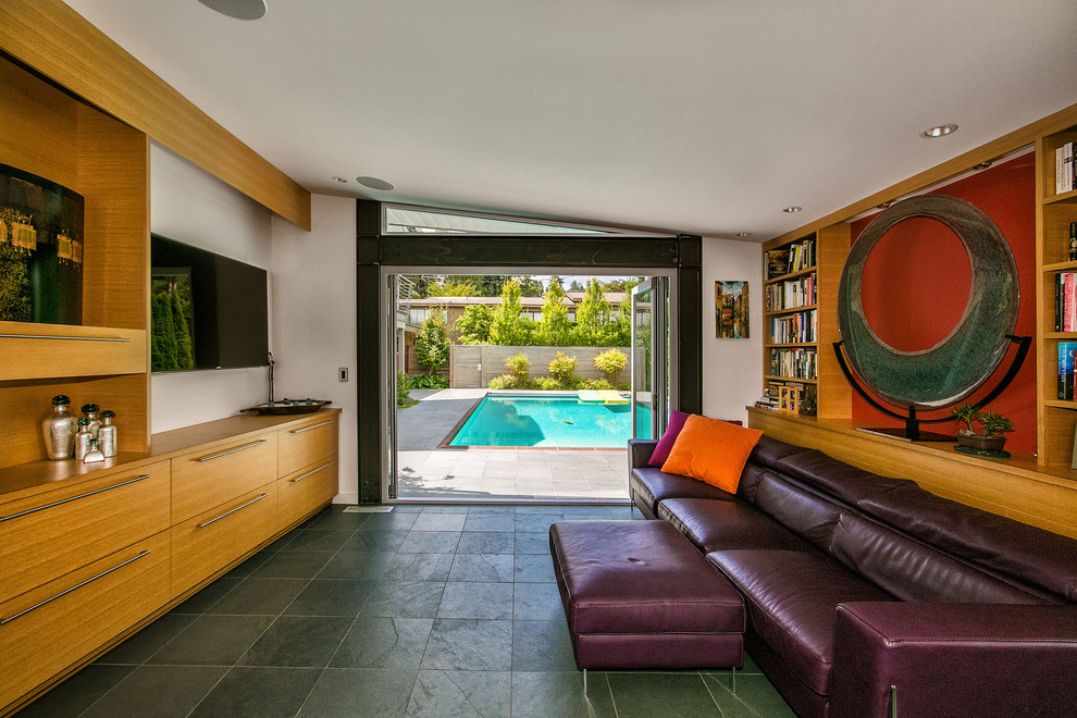 Esempio di un soggiorno minimalista di medie dimensioni e aperto con pavimento in ardesia, nessun camino, parete attrezzata e pareti rosse