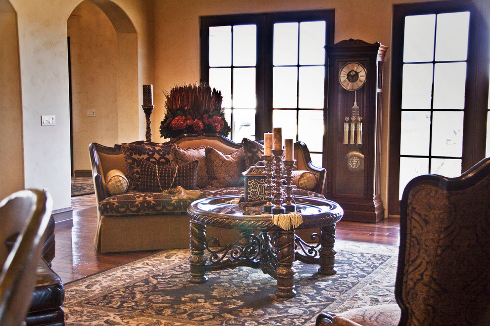 Mediterranes Wohnzimmer mit dunklem Holzboden, Kamin und Kaminumrandung aus Stein in Austin