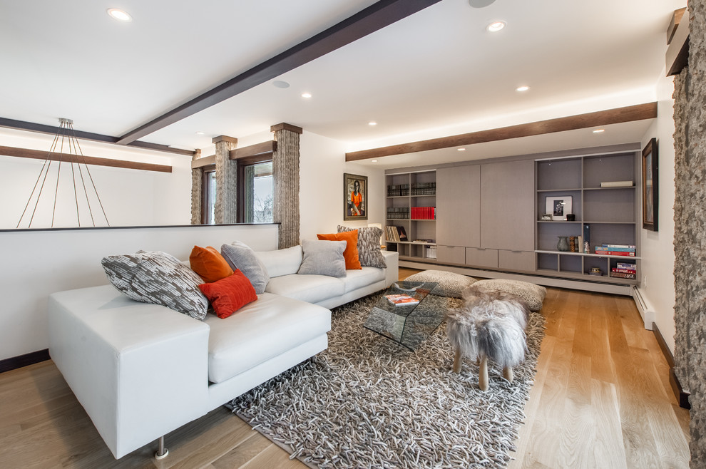 Idee per un grande soggiorno moderno stile loft con pareti bianche, parquet chiaro e TV nascosta