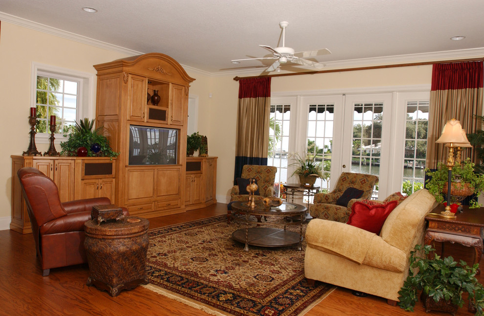 Foto de sala de estar cerrada mediterránea de tamaño medio sin chimenea con paredes beige, suelo de madera en tonos medios y televisor independiente