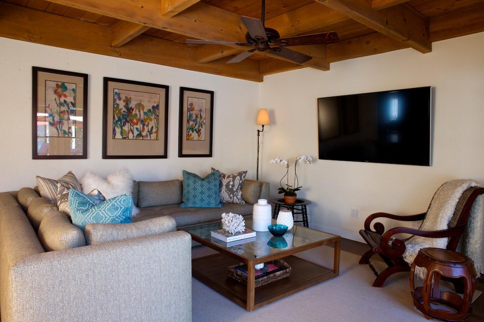 Modelo de sala de estar abierta tradicional renovada de tamaño medio sin chimenea con paredes blancas, suelo de madera oscura y televisor colgado en la pared