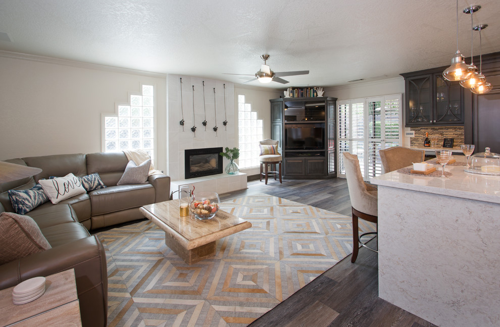 Cette photo montre une salle de séjour chic de taille moyenne et ouverte avec un mur beige, un sol en vinyl, une cheminée standard, un manteau de cheminée en carrelage et un téléviseur d'angle.