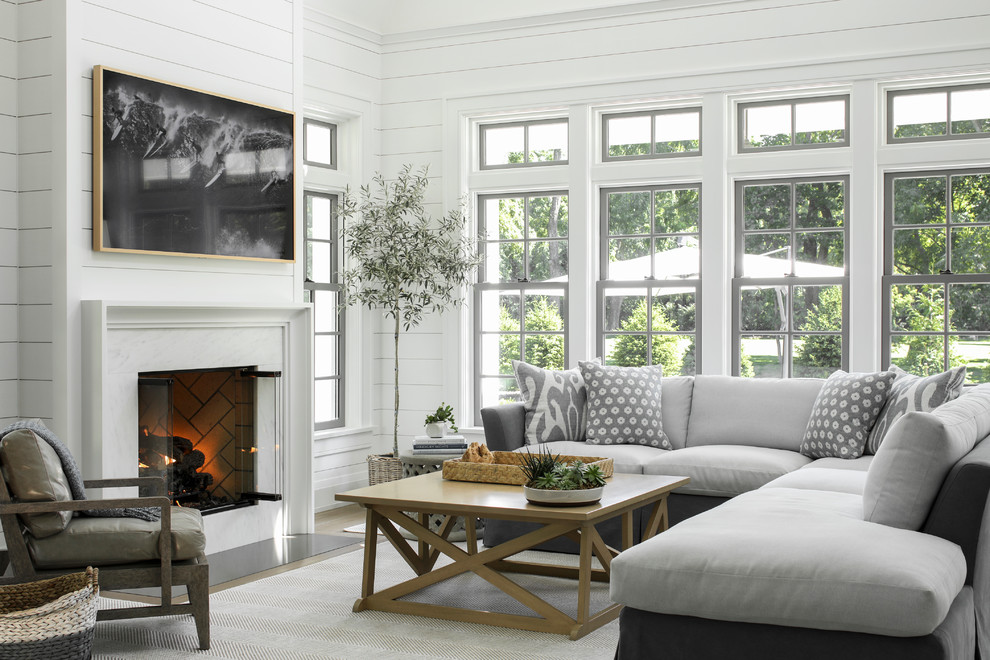 Idee per un soggiorno costiero con pareti bianche, pavimento in legno massello medio, TV a parete e pavimento marrone