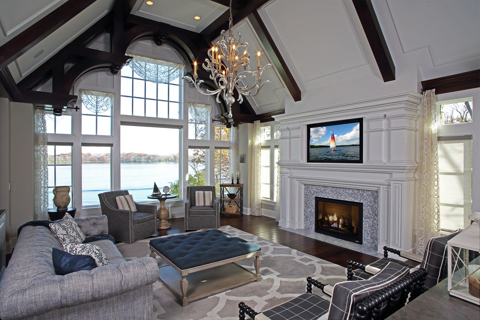 Large classic open plan games room in Minneapolis with beige walls, dark hardwood flooring, a standard fireplace, a tiled fireplace surround, a built-in media unit and brown floors.