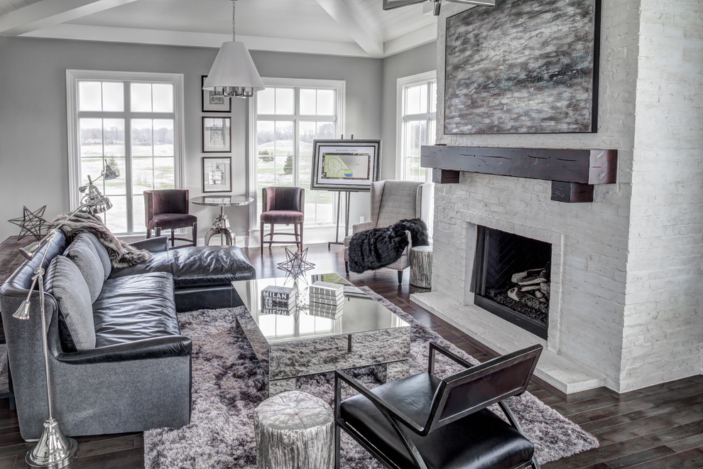 Example of a mid-sized country open concept dark wood floor family room design in Cleveland with gray walls, a standard fireplace, a brick fireplace and no tv