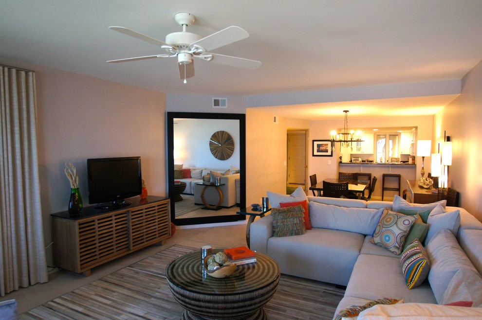Imagen de sala de estar abierta actual de tamaño medio sin chimenea con suelo de travertino, televisor independiente, suelo beige y paredes grises
