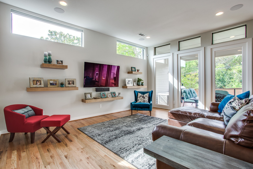 Immagine di un soggiorno tradizionale di medie dimensioni e aperto con pareti grigie, pavimento in legno massello medio, nessun camino, TV a parete e pavimento marrone