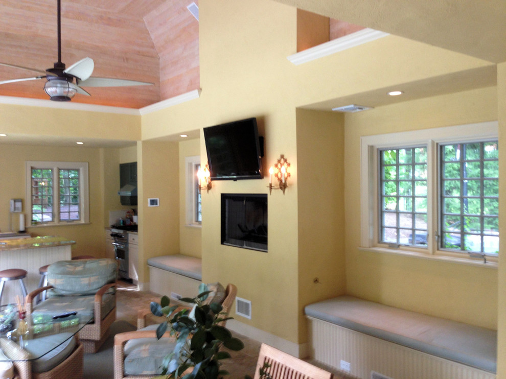 Cette photo montre une grande salle de séjour mansardée ou avec mezzanine moderne avec un mur jaune, un sol en calcaire, une cheminée standard, un téléviseur fixé au mur et un manteau de cheminée en plâtre.
