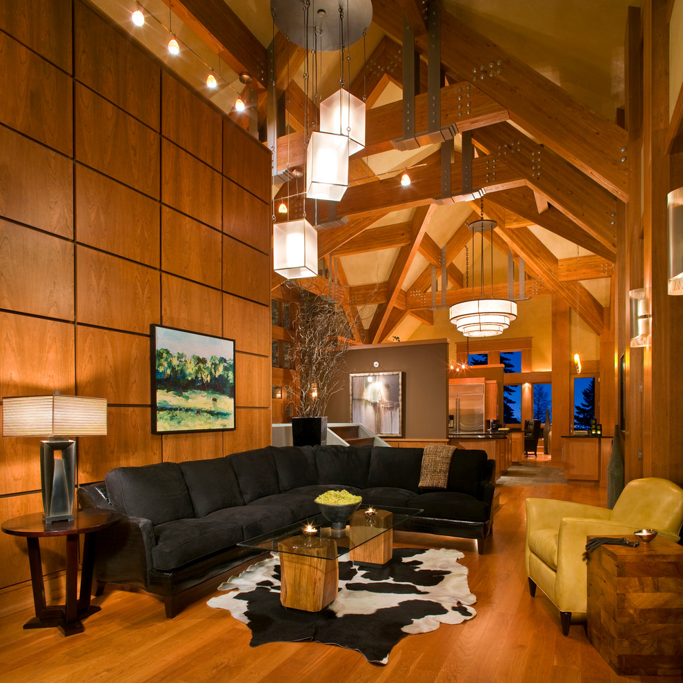 Example of a large mountain style open concept medium tone wood floor and brown floor family room design in Other with beige walls, no fireplace and a media wall