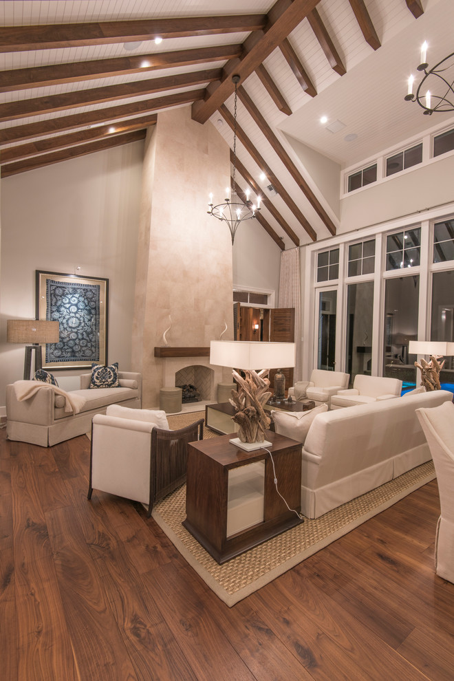 Family room - large tropical open concept light wood floor family room idea in Tampa with beige walls, a standard fireplace, a stone fireplace and no tv