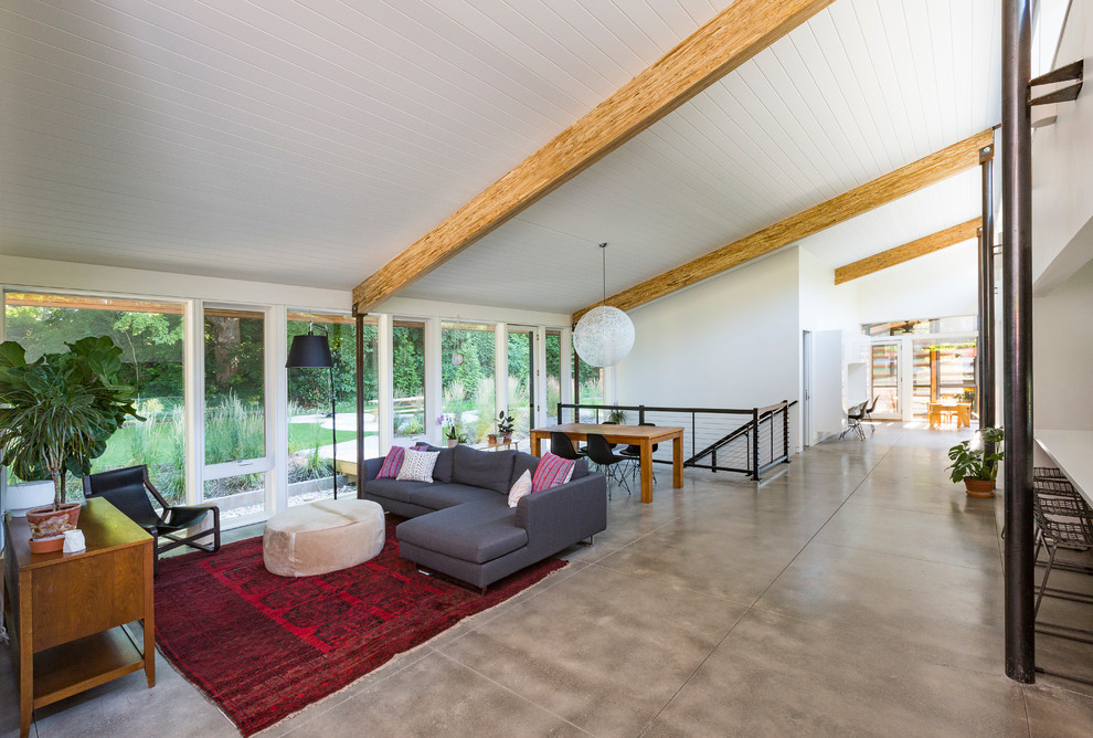 Свежая идея для дизайна: открытая гостиная комната в современном стиле с белыми стенами и бетонным полом без камина - отличное фото интерьера
