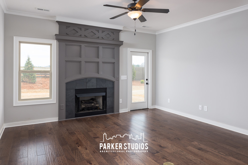Mittelgroßes, Fernseherloses, Offenes Klassisches Wohnzimmer mit grauer Wandfarbe, dunklem Holzboden, Kamin und Kaminumrandung aus Holz in Nashville
