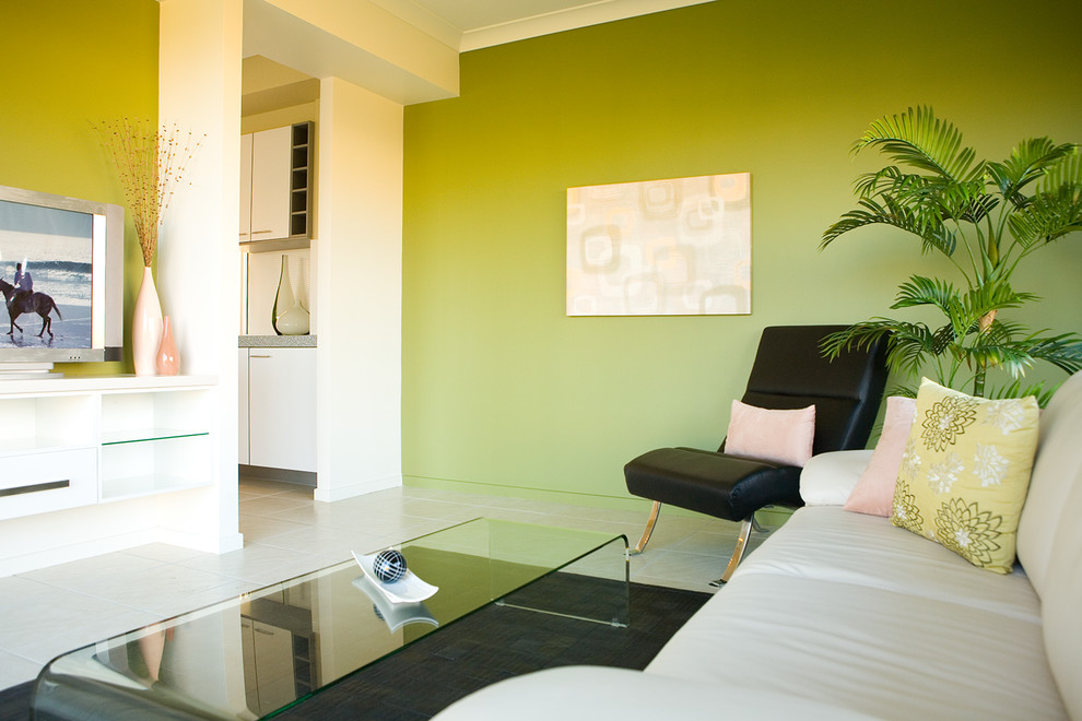 Ejemplo de sala de estar cerrada actual pequeña con paredes verdes, suelo de baldosas de cerámica y pared multimedia