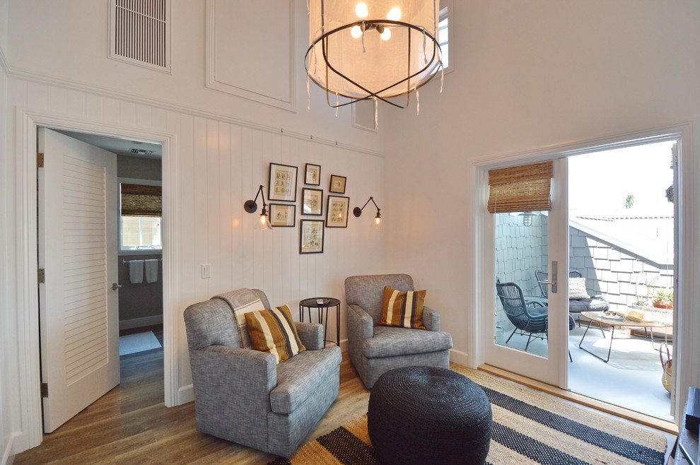 Foto de sala de estar cerrada marinera sin chimenea con paredes blancas, suelo de madera clara y televisor independiente