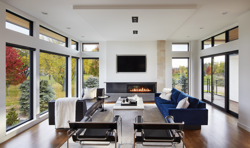 Imagen de salón abierto minimalista con paredes blancas, chimenea lineal, televisor colgado en la pared, suelo de madera oscura y alfombra