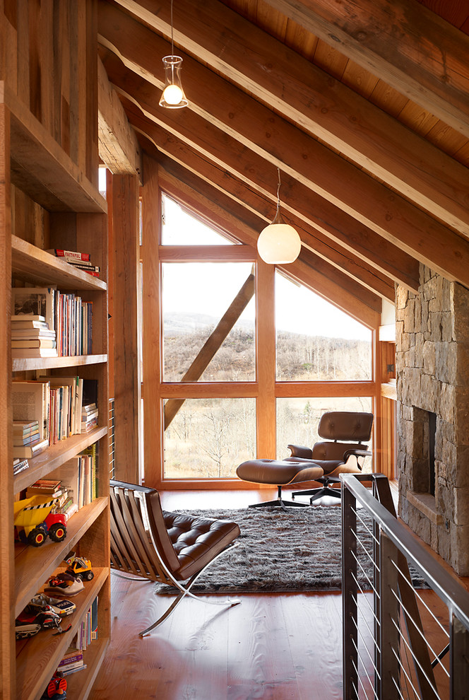 Идея дизайна: двухуровневая гостиная комната в современном стиле с с книжными шкафами и полками, стандартным камином и фасадом камина из камня