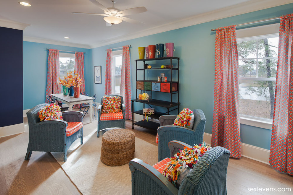 Offenes Klassisches Wohnzimmer ohne Kamin mit blauer Wandfarbe und hellem Holzboden in Charleston