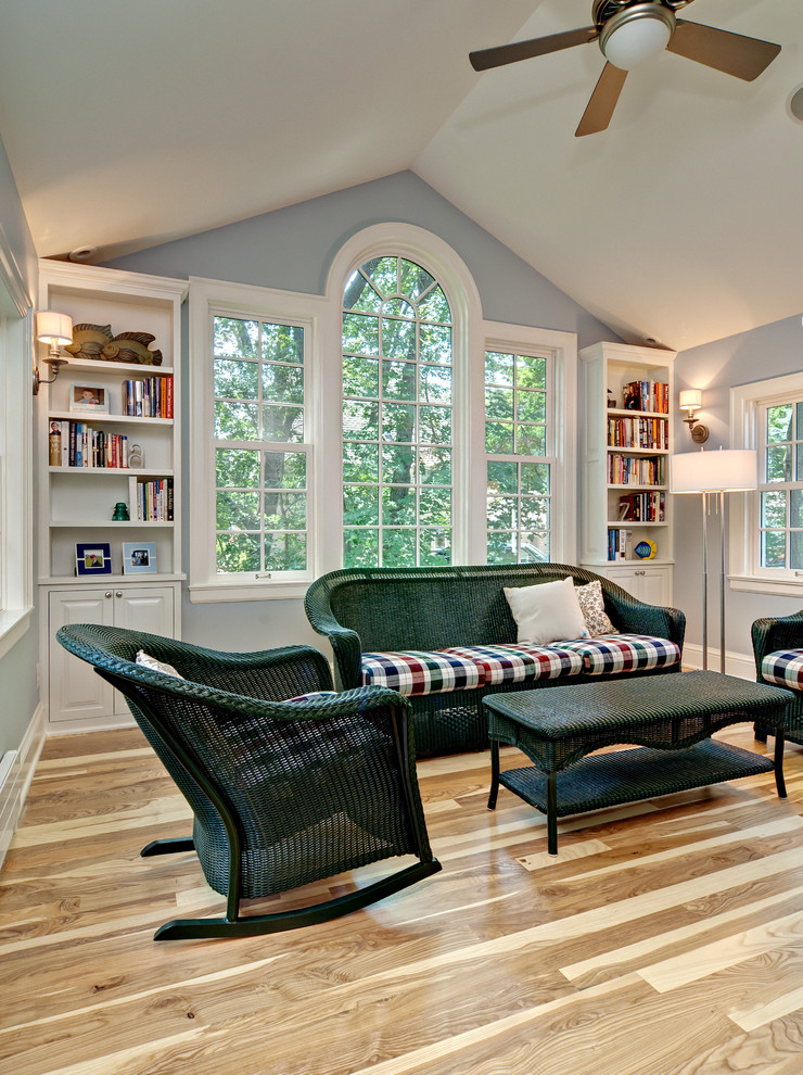 Ejemplo de sala de estar con biblioteca cerrada tradicional con paredes grises, suelo de madera en tonos medios y suelo beige