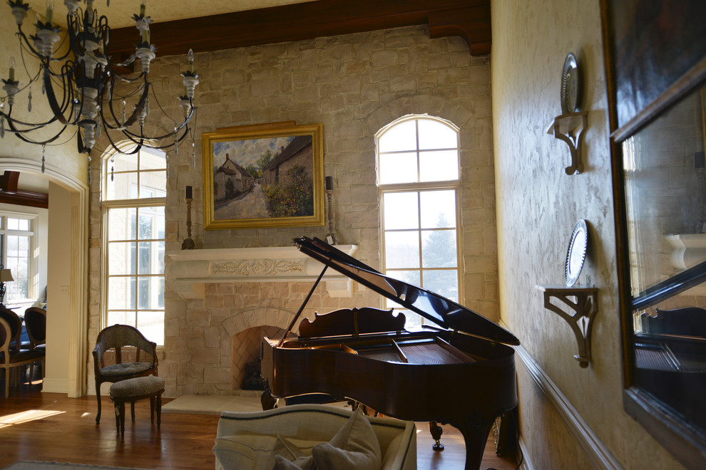 На фото: большая открытая гостиная комната в классическом стиле с музыкальной комнатой, паркетным полом среднего тона, стандартным камином, фасадом камина из камня, разноцветными стенами и коричневым полом без телевизора