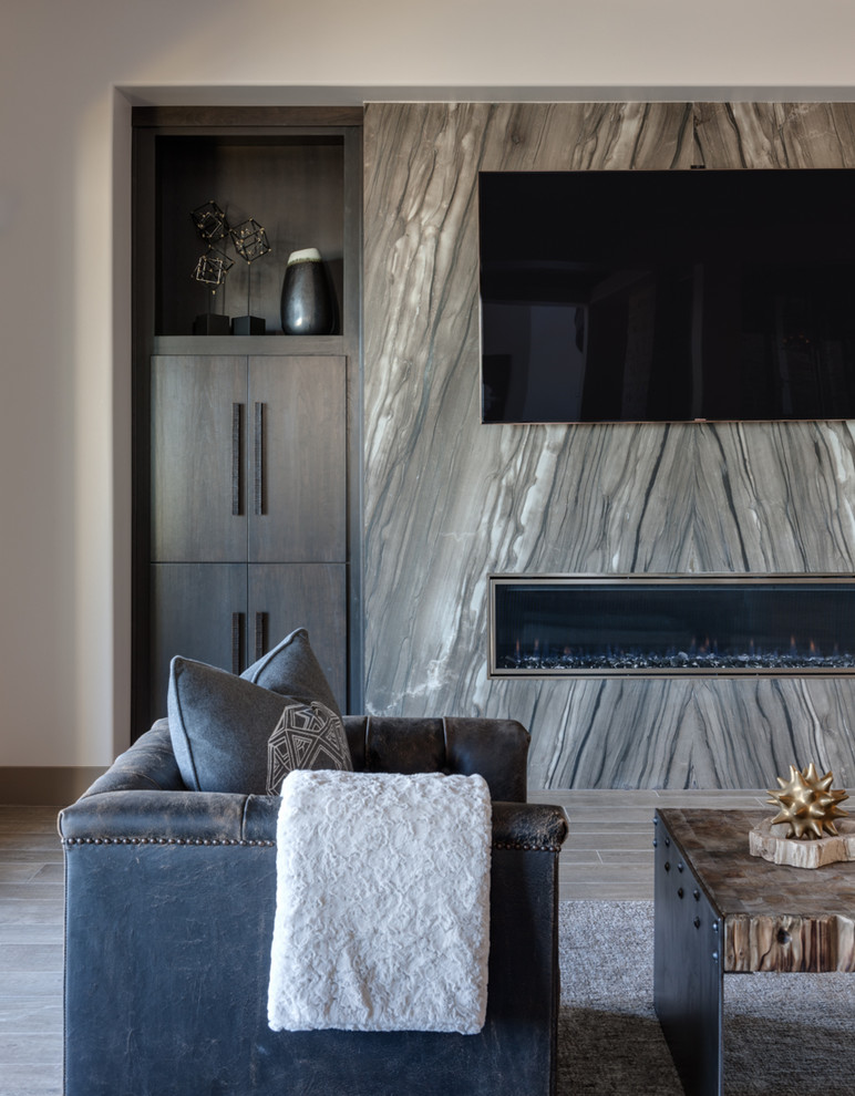 ラスベガスにあるお手頃価格の中くらいなコンテンポラリースタイルのおしゃれな独立型ファミリールーム (ベージュの壁、磁器タイルの床、横長型暖炉、金属の暖炉まわり、壁掛け型テレビ) の写真