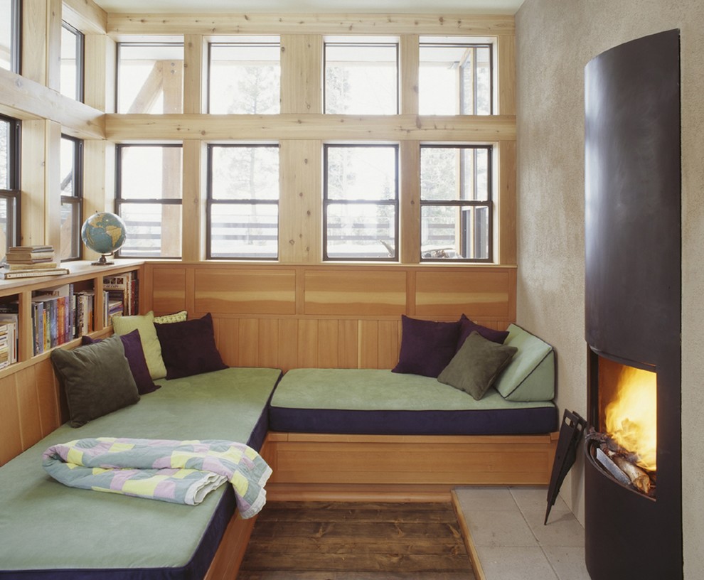 Aménagement d'une petite salle de séjour montagne fermée avec un mur beige, une bibliothèque ou un coin lecture, une cheminée standard, un manteau de cheminée en métal, aucun téléviseur et un sol beige.