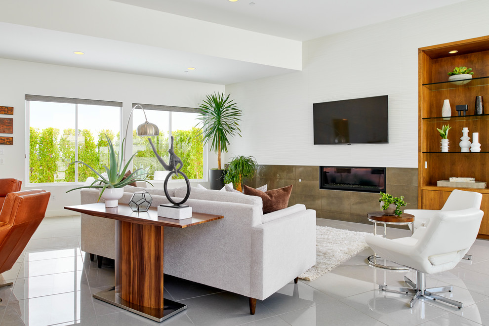 Идея дизайна: открытая гостиная комната в стиле ретро с белыми стенами, горизонтальным камином, телевизором на стене, белым полом и фасадом камина из плитки