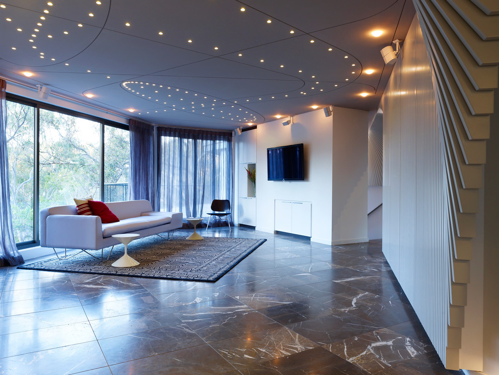 Réalisation d'une petite salle de séjour design ouverte avec un mur blanc, un sol en marbre et un téléviseur fixé au mur.