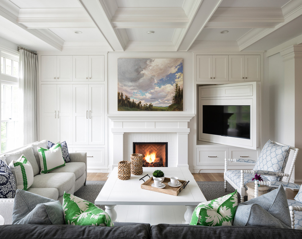 Immagine di un soggiorno stile marinaro con pareti bianche, parquet chiaro, camino classico, parete attrezzata, pavimento beige e tappeto